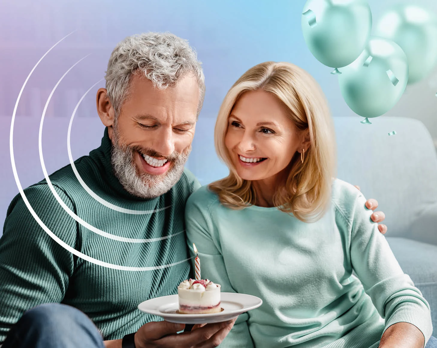 Glückliches Paar feiert Geburtstag mit Törtchen und Kerze, Ballons im Hintergrund